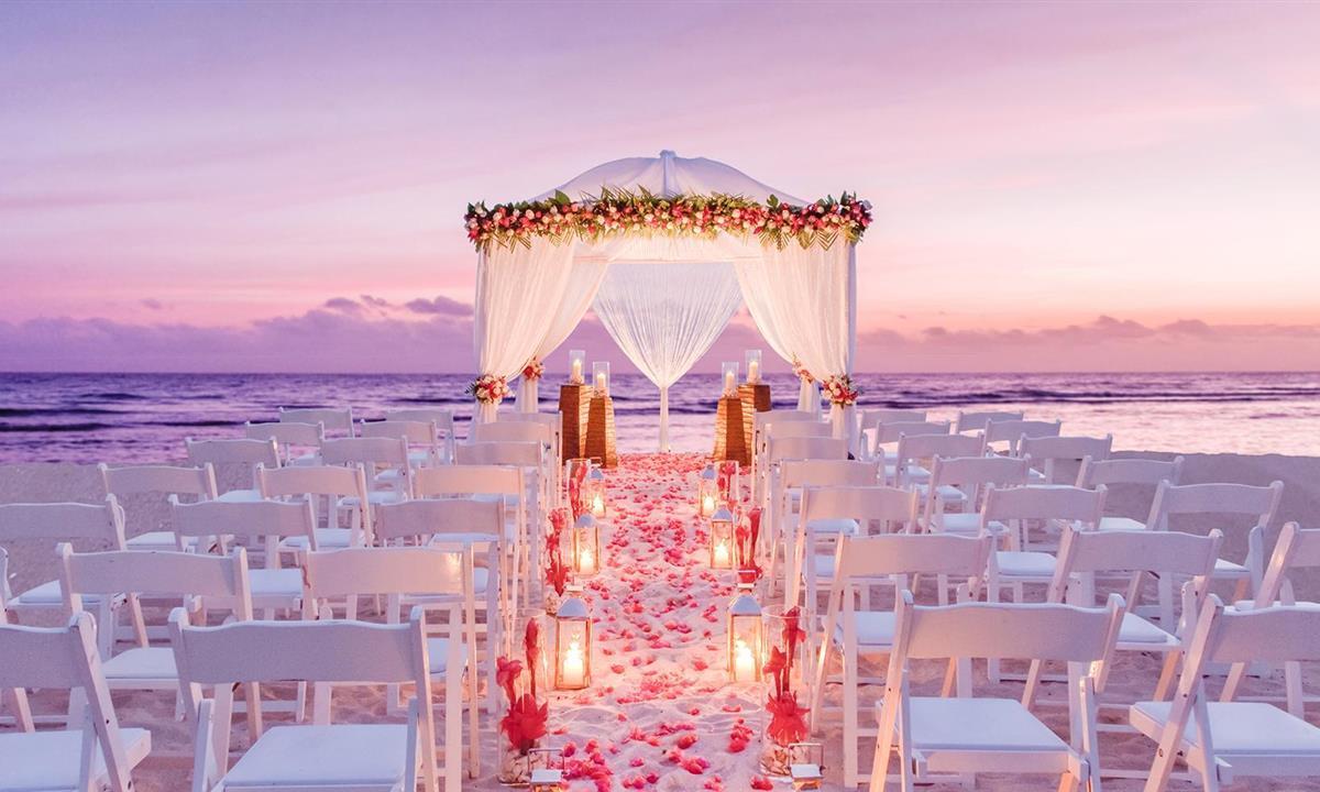 Outdoor wedding setup near the ocean at sunset