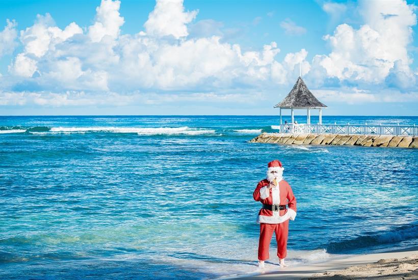 A person in a garment riding a bicycle in front of a building