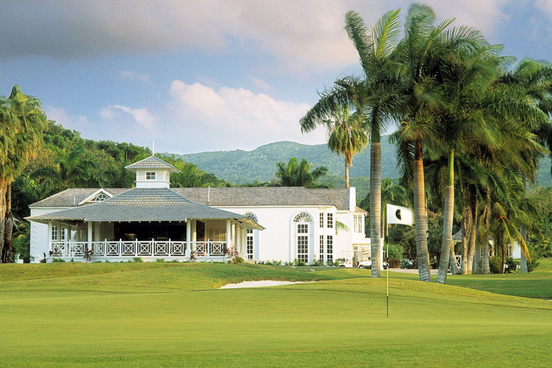 A golf course with sand bunkers and palm trees