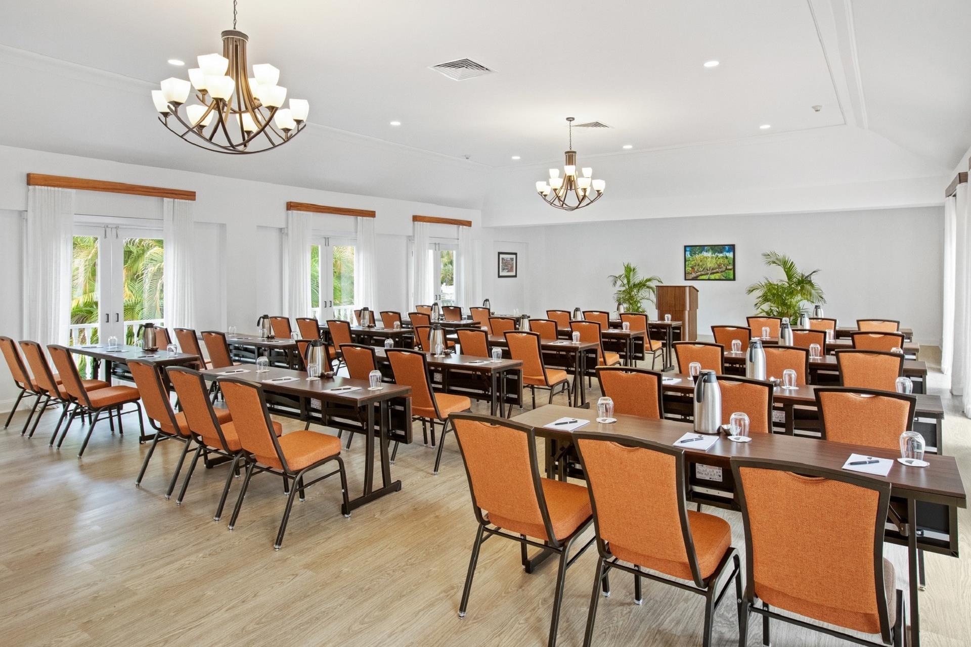 A room with chairs , tables and beige wooden floor