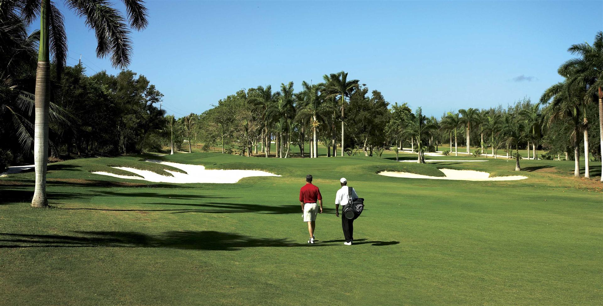 A couple of people walking on a golf course