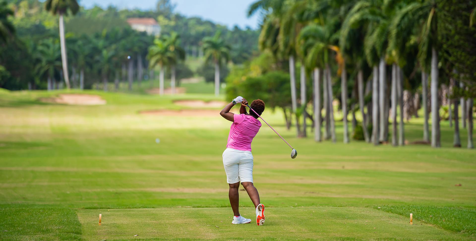 A woman swinging a golf club