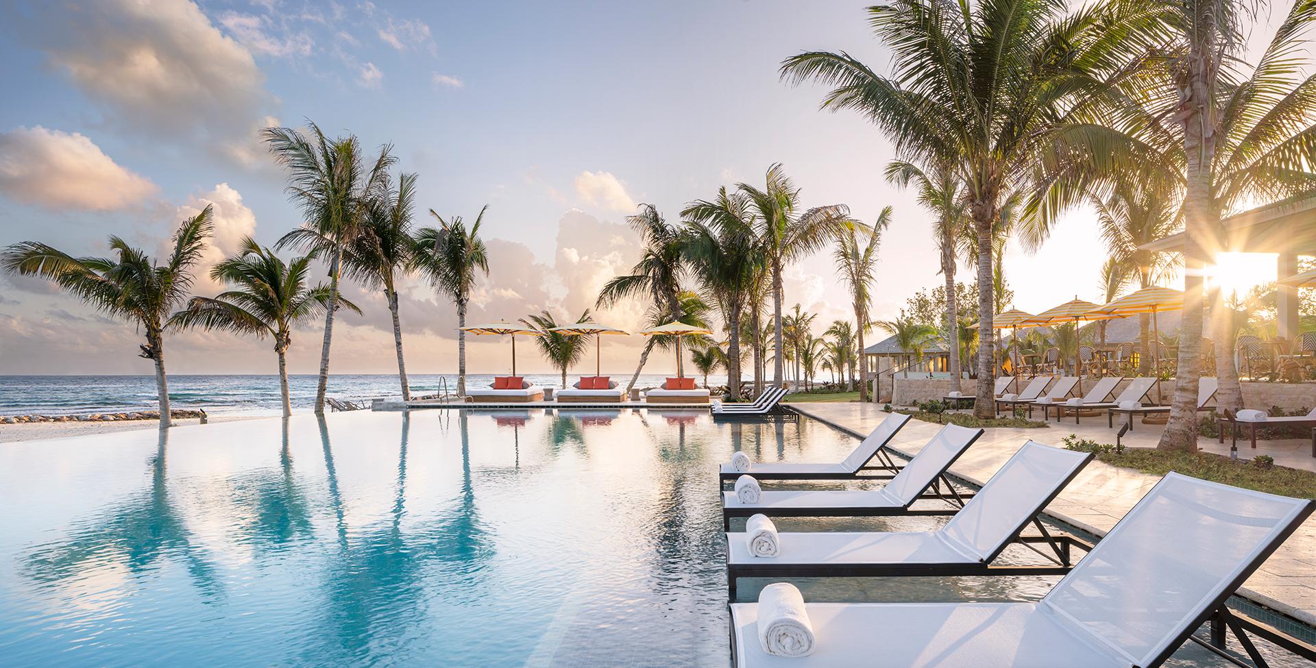 A pool with lounge chairs and palm trees